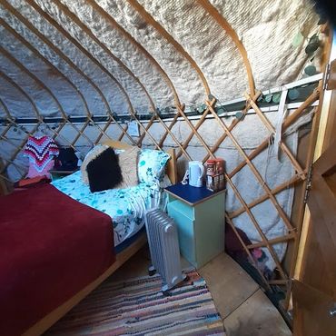 Interior of luxury yurt at Sunny Hill Campsite in Somerset with cosy bedding and furnishings