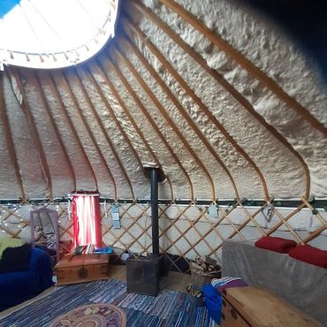 Traditional yurt accommodation with log burner and rustic interior in Somerset countryside