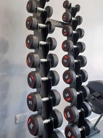 A gym dumbbell rack with weights from 4 to 20 kilograms.