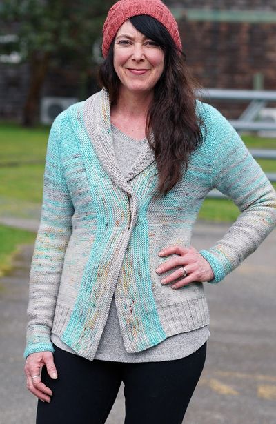 Woman wearing a knitted cardigan and pink beanie.