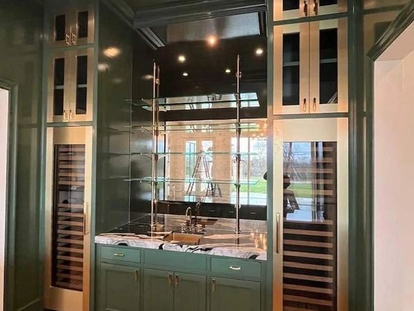 Custom cut glass shelves, mirrored wall, wine cooler doors.  Decorative glass bar.