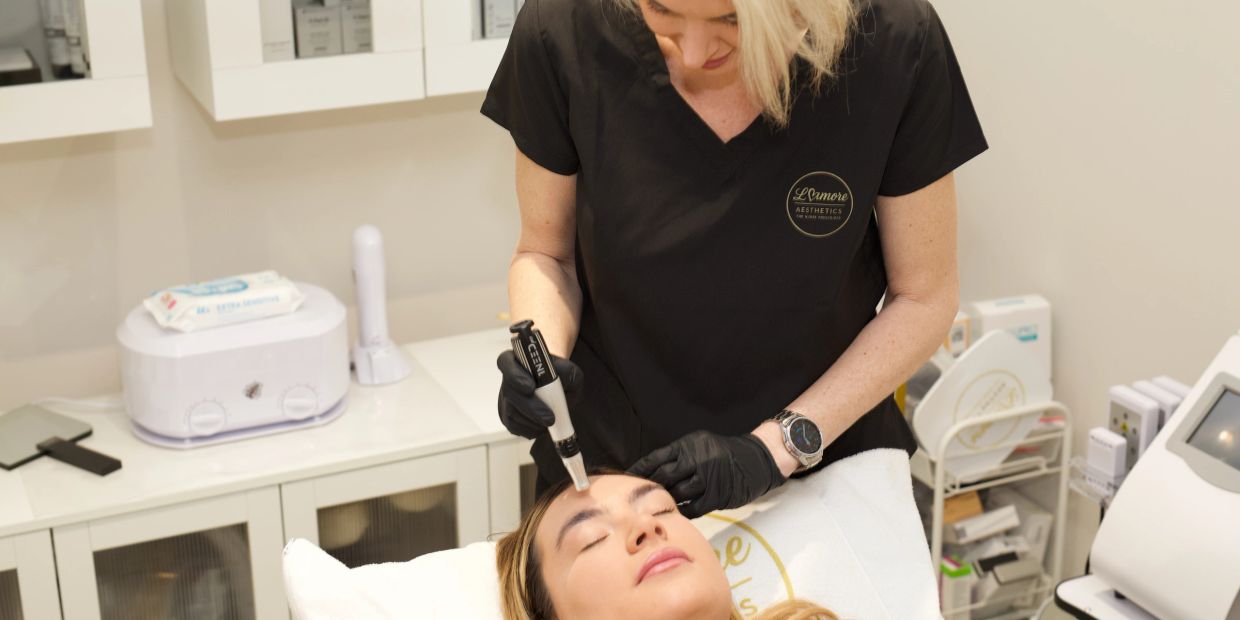 A beautician performing a facial treatment on a client.