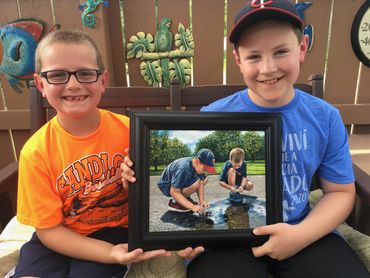 Grandsons Andrew & Nathan hold their painting “Cleaning & Inspection” painted May 2020