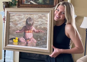 I painted this cute baby on a beach in 2005. Photo taken in 2021 with Bella, age 15 holding it.