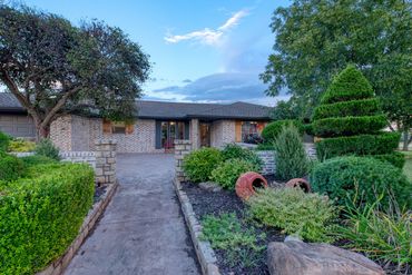 Elk City real estate photography—rural brick home exterior at dusk, landscaped walkway, Western OK
