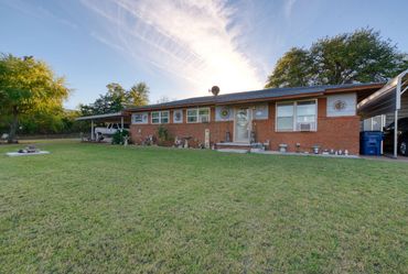 Eakly, OK brick ranch at dusk with wide lawn — Western Oklahoma real estate photo