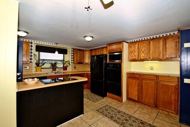Professional photograph of the kitchen of a home for sale in Sayre, OK. Includes view from window