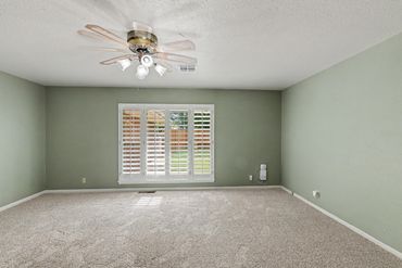 Empty living room with ceiling fan and carpet - real estate photo, Sayre, OK