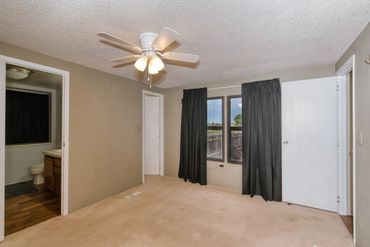 Professional photo of the bedroom of a home for sale in Sayre OK, includes view of backyard and bath