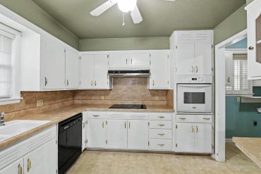 Kitchen with white cabinets and tile backsplash - real estate photo, Sayre, OK