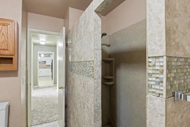 Tiled bathroom entryway with walk-in shower - real estate photo, Sayre, OK