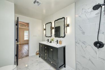Elk City bathroom with double sink vanity and marble tile
