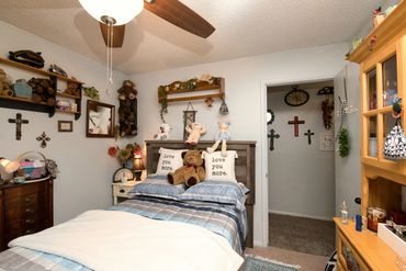 Eakly, OK bedroom with ceiling fan, twin bed and decor — Western Oklahoma rural home photo