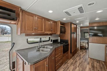 Well-lit photo of the cooking area and sink in an RV listed for sale in North Texas