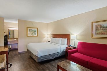 Guest room with bed and sofa at Northwest Inn hotel, Woodward, OK