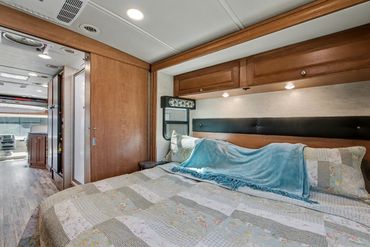 Well-lit photograph of the master sleeping area of an RV listed for sale in North Texas.