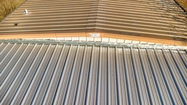 Closer aerial view of the junction between two metal roof sections