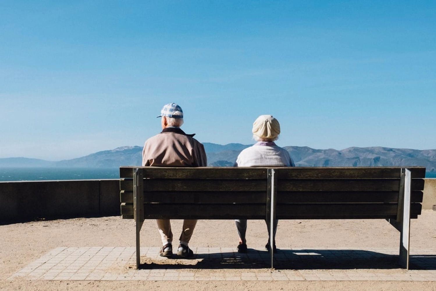 Senior couple on a bench enjoying a mountain view