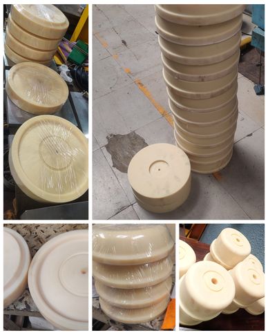 Various beige circular and cylindrical plastic parts in a workshop.