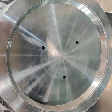 Polished metal disc with three holes and reflective finish.