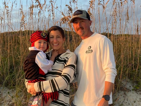 Family posing outdoors at sunset.