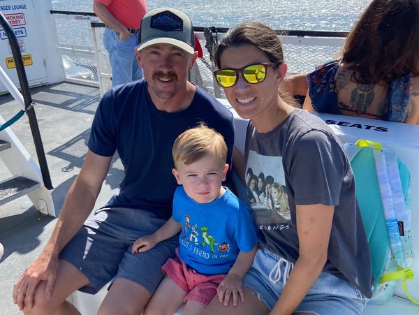 Family sitting together on a boat, smiling.