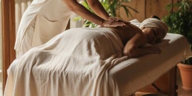 Person receiving a relaxing back massage in a serene spa setting.