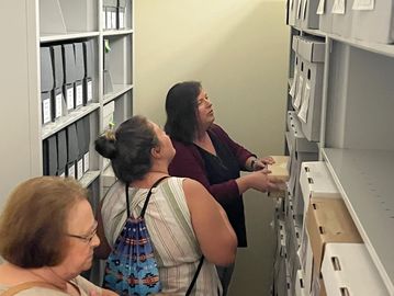 Image shows Anderson touring visitors in the archive.