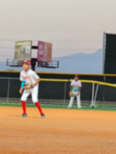 Two young baseball players on the field ready to play.