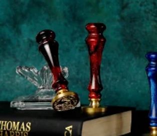 Three wax seals and a book with Thomas Harris on the cover.