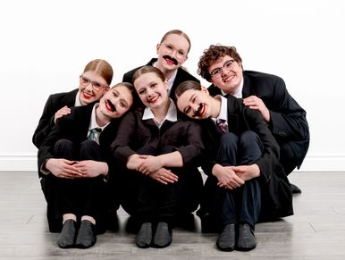 Group of six children in costumes posing together.
