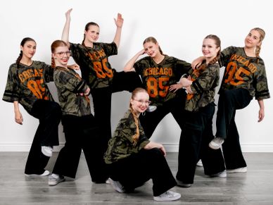 Group of six dancers posing in matching Chicago shirts.