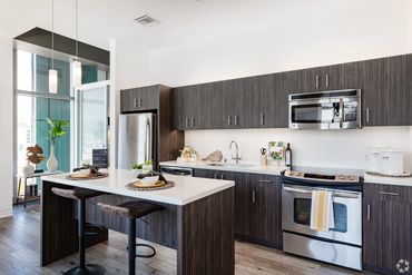 Modern kitchen with dark wood cabinets and stainless steel appliances.