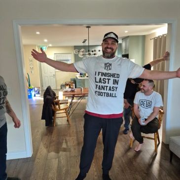Man in a T-shirt celebrating finishing last in fantasy football.