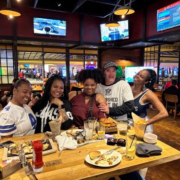 Group of friends enjoying food and drinks at a lively sports bar.