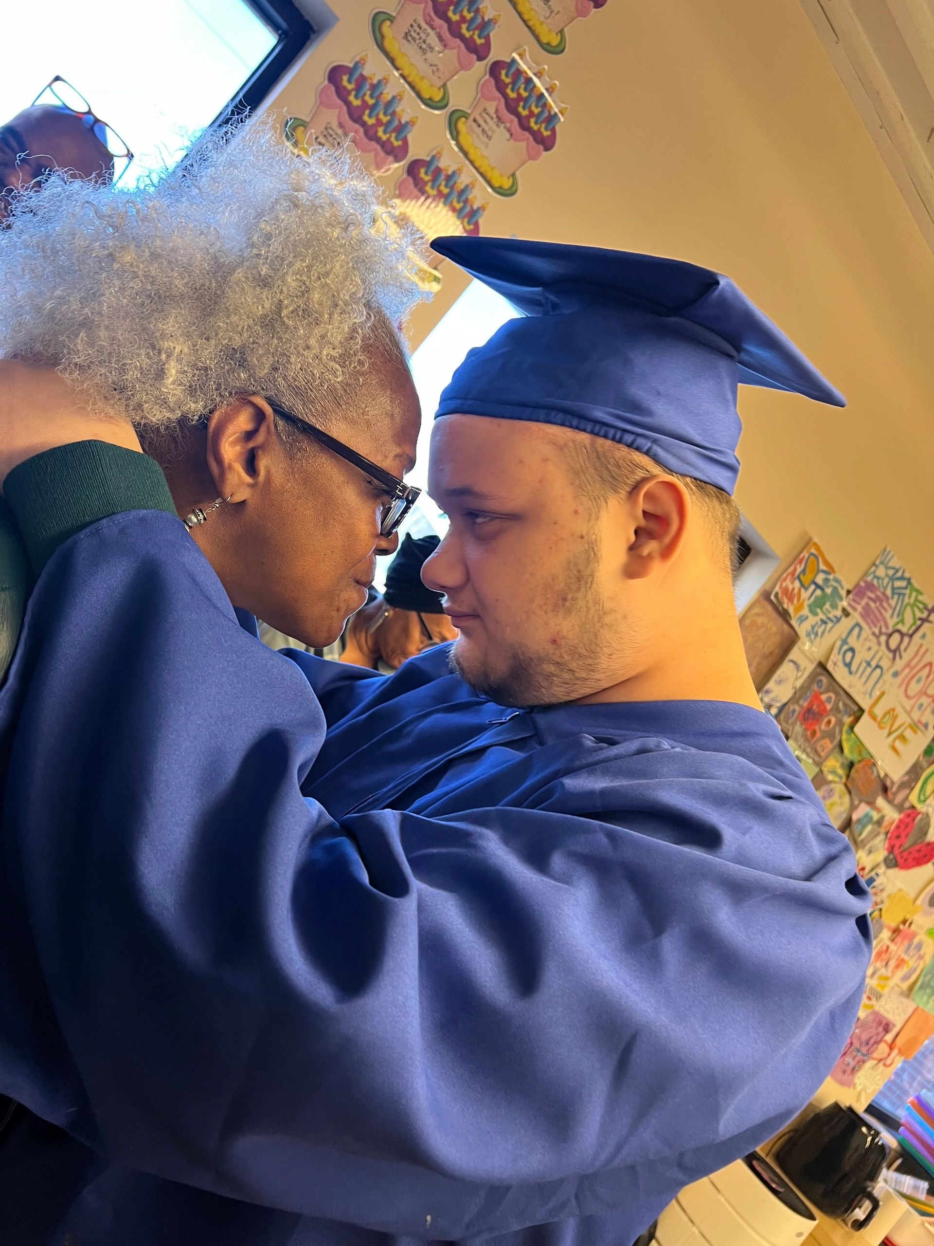 Graduate and elderly woman share a heartfelt moment.
