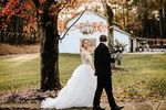Bride and groom walking in front of white barn wedding venue