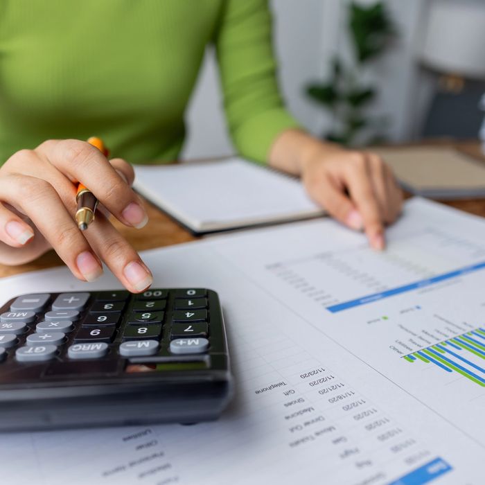 Person using a calculator and analyzing financial documents.