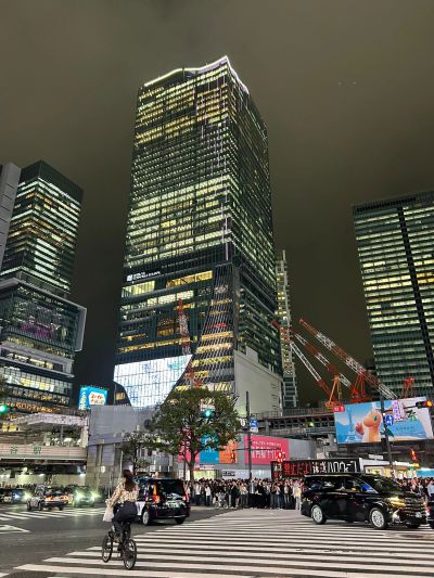 Busy city intersection at night with tall illuminated buildings.