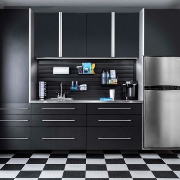 Modern black kitchen with stainless steel appliances and checkered floor.