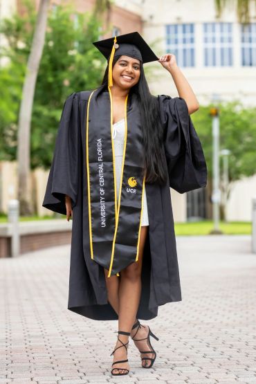 Smiling graduate in cap and gown from University of Central Florida.