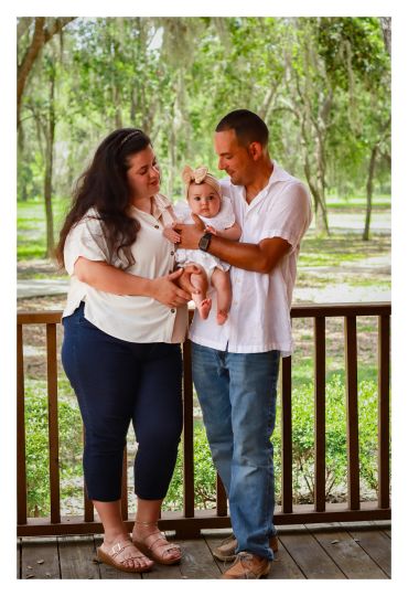 Happy family outdoors with their baby.