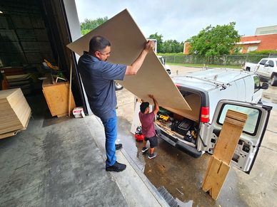 The manager of our Houston store lending a hand to load up a customers vehicle with plywood.