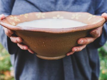 Hands holding woodfired stoneware bowl made by Lisa Barry