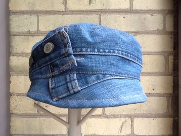 A blue denim newsboy inspired cap with button embellishments.