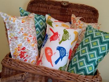 Many pillows in a wicker box.