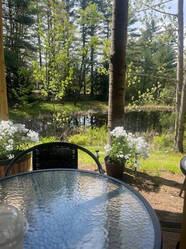 Table and chairs set up to sit and relax by the pond at the Holistic Alignment Healing Center