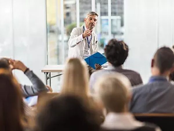 A veterinarian is lecturing to a group of veterinarians attending a continuing education class.
