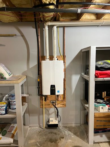 Tankless water heater installed in a basement with storage shelves nearby.