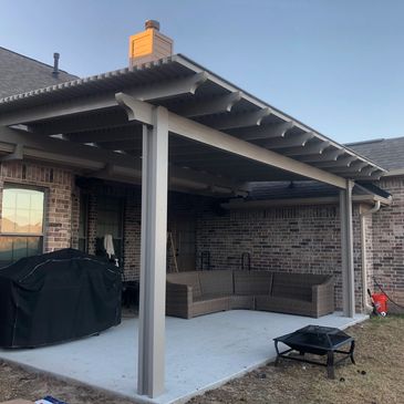all aluminum pergola with a smoke color poly carbonate top beige and brown color brick